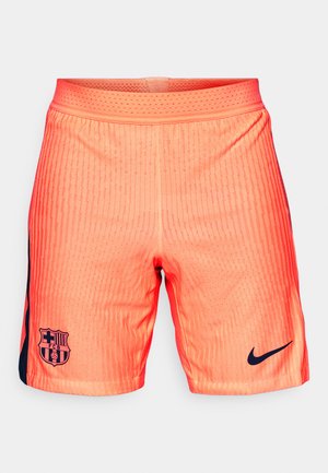 Narandžaste atletske šortse sa prugastom teksturom, sa tamnoplavim bočnim panelom, logotipom Barselone i Nike swoosh-om na donjem desnom delu.