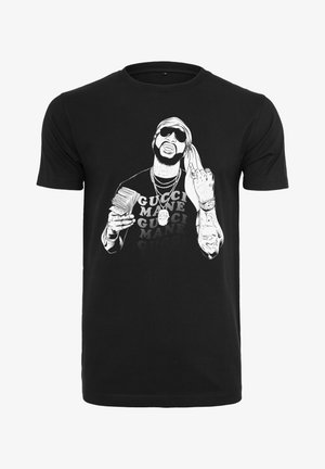 Mustmust värvi t-särk, millel on graafika prillidega mehest, kes hoiab rahatähti, ja paksus kirjas "GUCCI MANE" tekst.