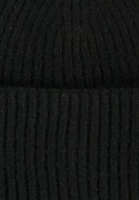 Berretto a maglia nero con texture a coste, materiale morbido in misto lana, forma cilindrica e dettaglio con risvolto.