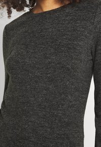 Dunkelgrauer Pullover mit langen Ärmeln aus strukturiertem Stoff, mit einem Rundhalsausschnitt und taillierter Passform für einen schlanken Look.