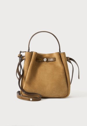 Sac à main en daim marron avec une poignée supérieure unique et une bandoulière réglable sur fond clair uni.
