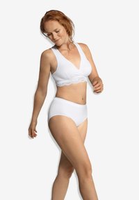 Vit bralette med spetsdetaljer och en twist-design på bysten, tillsammans med högmidjade vita underkläder, båda tillverkade av ett mjukt, stretchigt material.