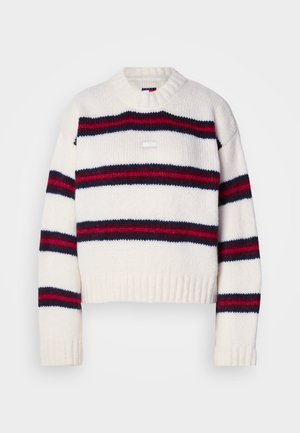 Pleteni skraćeni pulover u krem boji s horizontalnim prugama u mornarskoj plavoj i crvenoj. Okrugli izrez i rebrasti detalj na rubu. Tekstuirana tkanina.