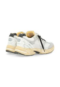 Sneaker bianchi e grigi con accenti neri, materiale testurizzato, punta rotonda, collo imbottito e suola in gomma. Presentano chiusura con lacci e dettaglio del logo.