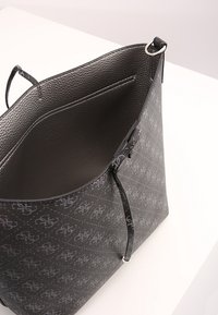 Bolso tote de cuero negro con un acabado texturizado, que presenta un exterior estampado, apertura superior y un bolsillo interior. Detalles sutiles del logo.