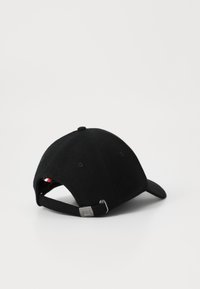 Casquette de baseball noire avec une visière courbée, fabriquée en tissu avec une finition texturée. Elle présente une sangle ajustable en métal et un petit logo à l'arrière.