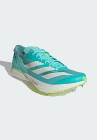Scarpa da pista leggera in aqua e bianco. Presenta una tomaia in mesh, un motivo testurizzato, lacci piatti e suola chiodata per la trazione.