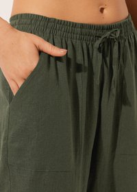Pantalons légers vert olive avec cordon de serrage et taille élastique. Comprend des poches latérales et une coupe décontractée avec une texture douce.