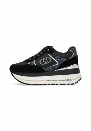 Sneaker nera con suola piatta, caratterizzata da una combinazione di suede e tessuto scintillante. Decorata con dettagli in metallo argentato e un logo.