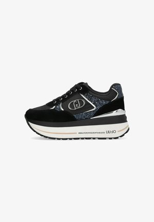 Sneaker nera con suola piatta, caratterizzata da una combinazione di suede e tessuto scintillante. Decorata con dettagli in metallo argentato e un logo.