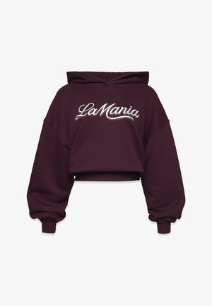 Przycięta ciemnofioletowa bluza z dużymi rękawami i ściągaczami, z białym, kursywnym napisem "La Mania" z przodu.