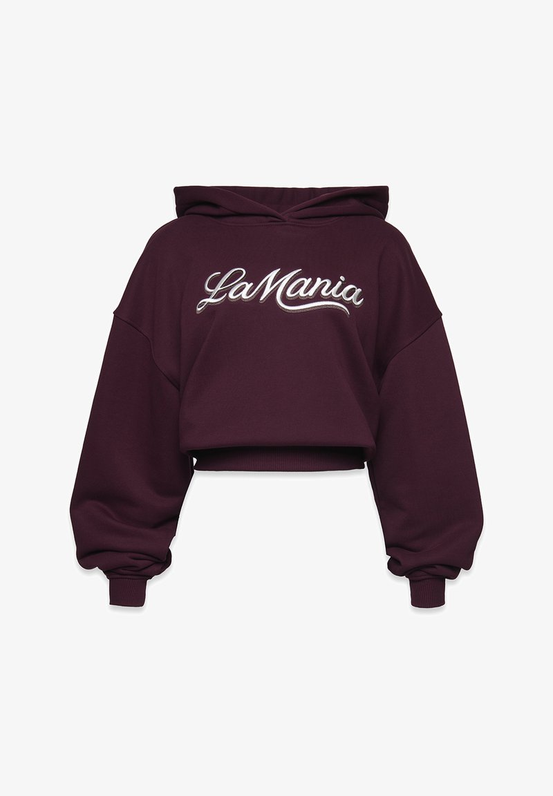 Rövidített sötétlila kapucnis pulóver, túlnyúló ujjakkal és bordás mandzsettákkal, a mellen fehér írással "La Mania" felirattal.