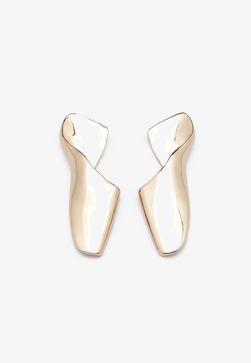 Orecchini in tonalità oro con una forma scultorea attorcigliata e una superficie liscia e riflettente. Design minimalista senza chiusure visibili.