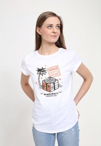 Biała bawełniana koszulka z grafiką z Minecrafta przedstawiającą kostkę, palmę oraz napis "BUDUJ TWÓRZ BADŹ" w pomarańczowym i czarnym kolorze.