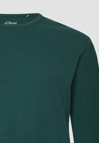 Donkergroene T-shirt met lange mouwen van zacht katoen. Heeft een ronde halslijn en subtiele stikdetails. Merklogo zichtbaar bij de hals.