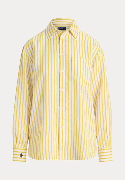 Yellow and white vertical striped button-up shirt with long sleeves, a chest pocket, and a small embroidered logo on the left cuff.