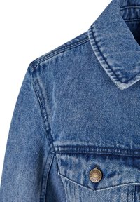 Cuello de chaqueta de mezclilla en un color azul claro, con tejido texturizado, costuras visibles y un botón metálico con detalles grabados.
