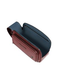 Bordeauxrode leren tas met een gladde textuur en een blauwe voering, voorzien van een ritssluiting en meerdere vakken voor organisatie.