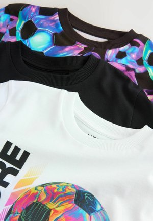 Trois sweatshirts à col rond : noir avec un graphique de ballon de soccer coloré, blanc avec un texte en gras et un ballon coloré, et un graphique vibrants en bleu et violet.