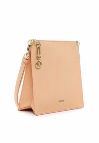 Håndtaske i ferskenfarvet tekstureret læder med gulddetaljer, en aftagelig rem og en lille cirkulær guldsmykke, der hænger nær toppen.