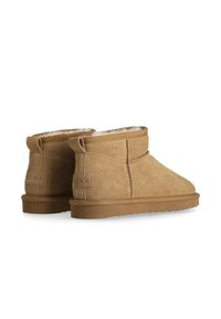 Ljusbruna mocka ankle boots med runda tår, mjukt foder och platta gummisulor. Har en sömdetalj och logotypdetalj bak.