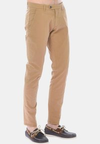 Chinos in cotone beige con vestibilità slim, dotati di tasche anteriori, zip e chiusura con bottone. Abbinati a scarpe da barca scure.