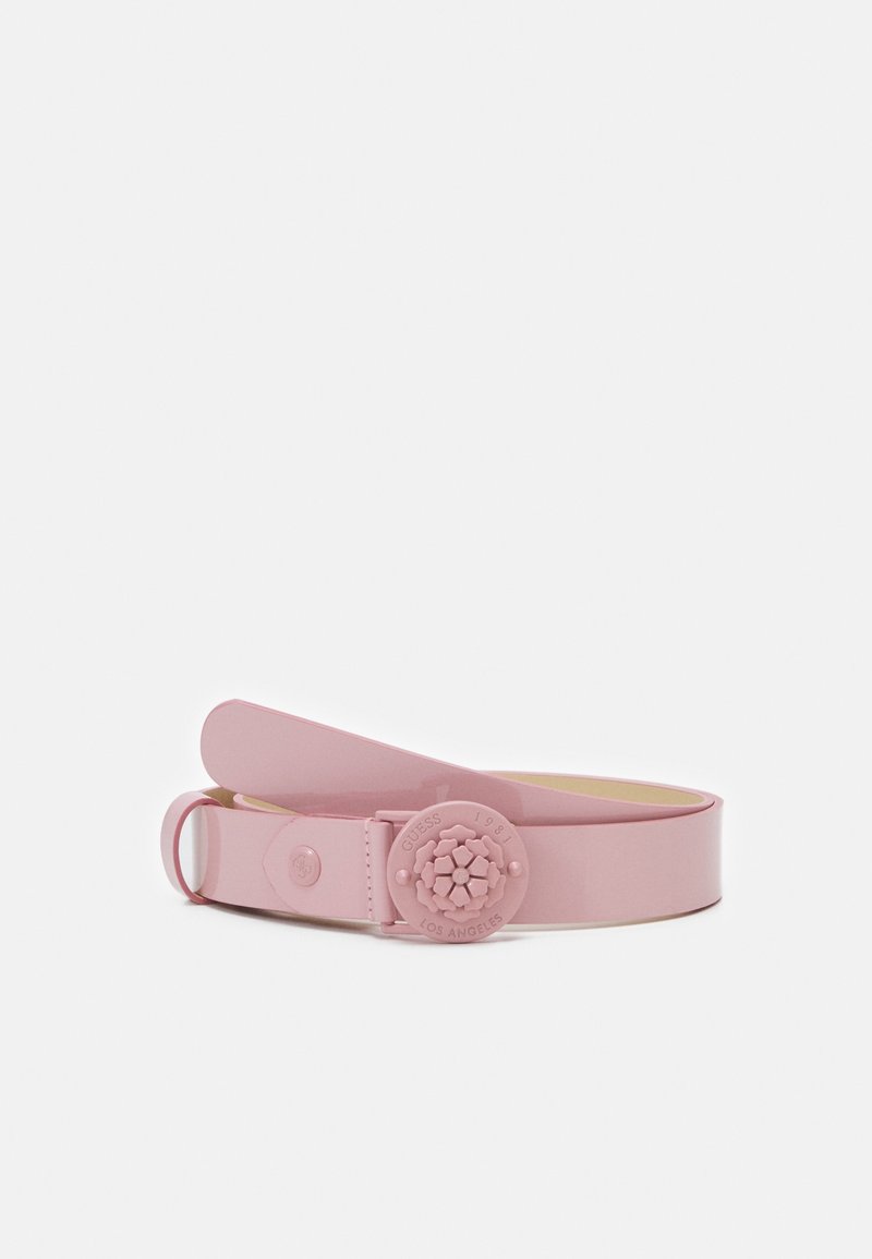 Ceinture rose clair roulée avec boucle ronde embossée de motifs floraux et petit anneau métallique sur fond blanc uni.