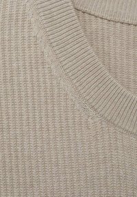 Maglione beige lavorato a maglia con una ampia trama a coste e un colletto rotondo. Il tessuto appare morbido con dettagli di cucitura rifiniti con cura.