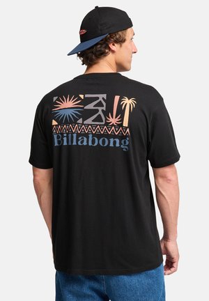 Sort bomuld T-shirt med farverige geometriske grafikker og "Billabong" tekst på bagsiden. Kortærmet og med rund halsudskæring.