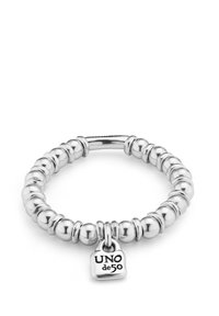 Bracelet élastique de couleur argentée avec des perles rondes et une petite plaque gravée "UNO de 50". Finition lisse et brillante avec un design uniforme.