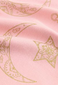 Rosa Stoff mit goldenen, bedruckten Halbmond- und Sternmotiven sowie aufwendigen Blumenmustern und einer weichen, strukturierten Oberfläche.