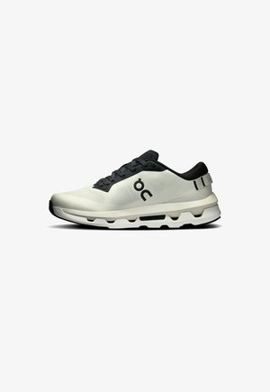 Chaussure de sport avec un schéma de couleurs blanc et noir, tige en mesh pour la respirabilité, semelle intermédiaire rembourrée et semelle extérieure en caoutchouc à motifs.