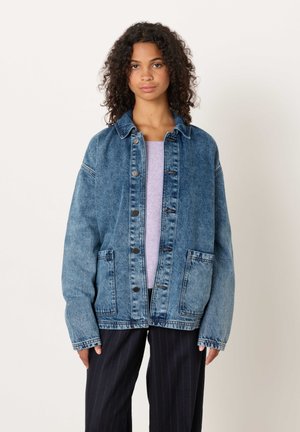 Jeansjacka i ljus till mediumblå nyans. Har två framfickor, knappstängning och en något oversize passform med krage.