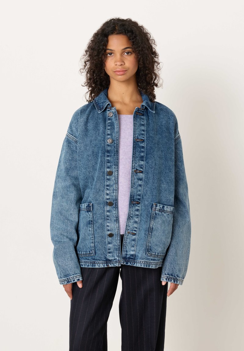 Jeans jakna v svetlo do srednje modri barvi. Ima dva prednja žepa, zapenjanje na gumbe in rahlo ohlapno prileganje s ovratnikom.