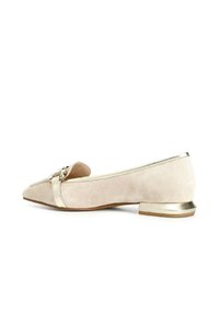 Beige Wildleder Ballerinas mit einem metallic goldenen Absatz und dekorativem Schnallen-Detail. Schlanke Silhouette mit spitzem Zehendesign.