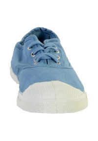 Baskets en toile bleue avec semelle et capuchon en caoutchouc blanc, vue de face montrant les lacets et les œillets en métal.