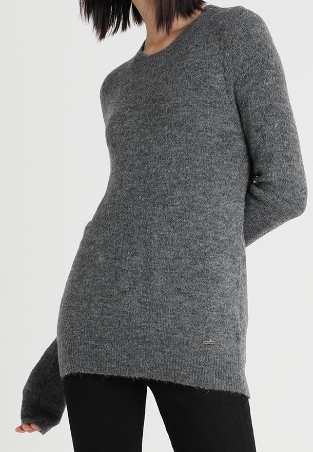 Maglione grigio a maglia con maniche lunghe, scollatura rotonda, orlo a coste e una consistenza morbida. Presenta un piccolo logo sul lato inferiore.