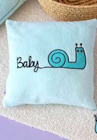 A soft, light blue square pillow featuring an embroidered cartoon snail and the word "Baby" in black cursive stitching.