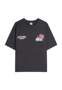 Fekete pamut póló rövid ujjakkal. Bal oldalon fehér szöveg, jobb oldalon rózsaszín és zöld virágmintás grafika.