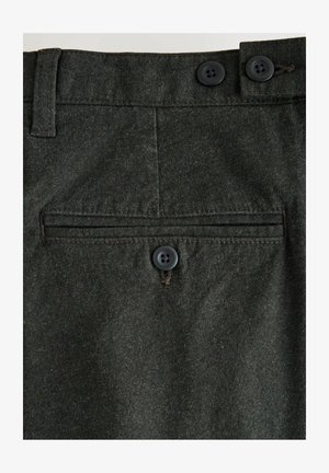 Szczegóły ciemnoszarych wełnianych spodni z dwoma czarnymi guzikami w pasie oraz jednym guzikiem zapięcia poziomej tylnej kieszeni.