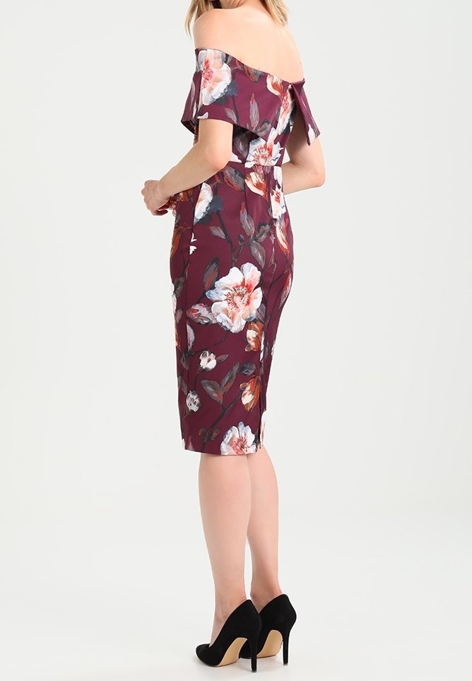 Robe bordeaux décolletée avec imprimé floral, silhouette ajustée, longueur genou, avec des manches volantes et un nœud dans le dos.