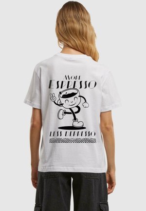 Valkoinen puuvillainen t-paita, jossa on sarjakuvamainen kahvikuppigrafiikka ja teksti "More Espresso Less Depresso" mustana. Yksinkertainen, rento muotoilu.