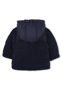 Veste matelassée bleu marine avec texture côtelée, une capuche en duvet et des poignets élastiques. Le tissu est doux et isolé pour la chaleur.
