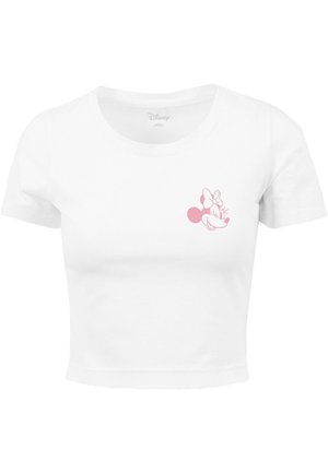 T-shirt blanc court en coton avec une illustration imprimée en rose du visage d'un personnage sur le côté gauche de la poitrine. Manches courtes, encolure ronde.