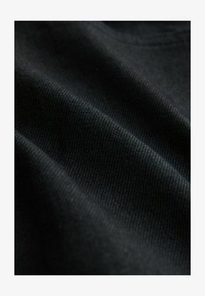 Fekete kötött anyag, sima textúrával, enyhe rugalmassággal; látható redők és barázdák hangsúlyozzák könnyű kialakítását.