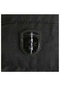 Svart sköldformad patch med en stjärn-emblem och texten "MELLEMSVEXX" på mörk texturerad tyg.