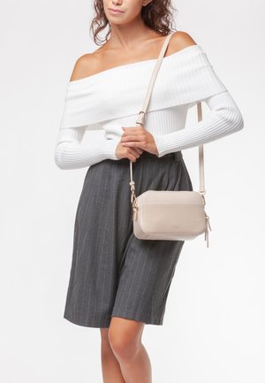 Borsa a tracolla beige realizzata in materiale liscio, caratterizzata da una forma rettangolare, hardware dorato e chiusura con zip dotata di dettaglio a nappina.