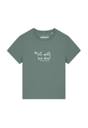 T-shirt en coton vert avec des manches courtes et un col rond. Présente le texte blanc "Ich zähl bis drei !" sur le devant.