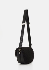 Black crossbody bag with a textured fur exterior and leather accents. Features a wide strap with logo and gold hardware.