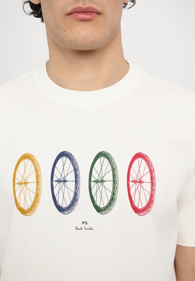 Bela bombažna majica s štirimi grafikali kolesnih platišč v rumeni, modri, zeleni in rdeči barvi. Pod njo je napisan tekst "PS Paul Smith".